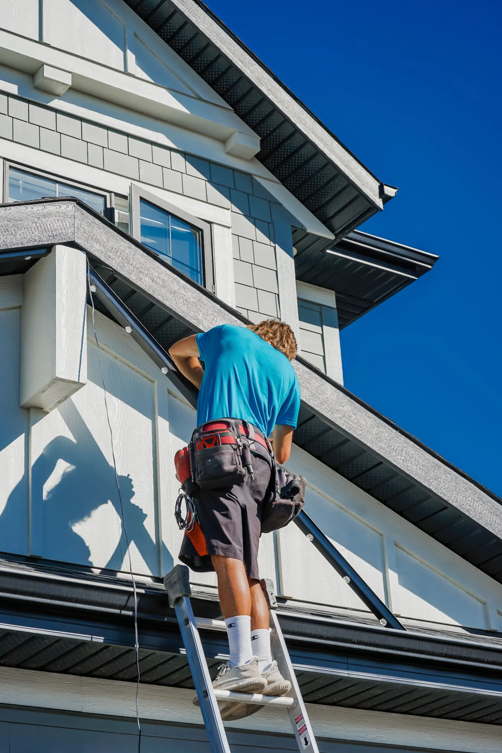 Installer working on outdoor lighting tracks