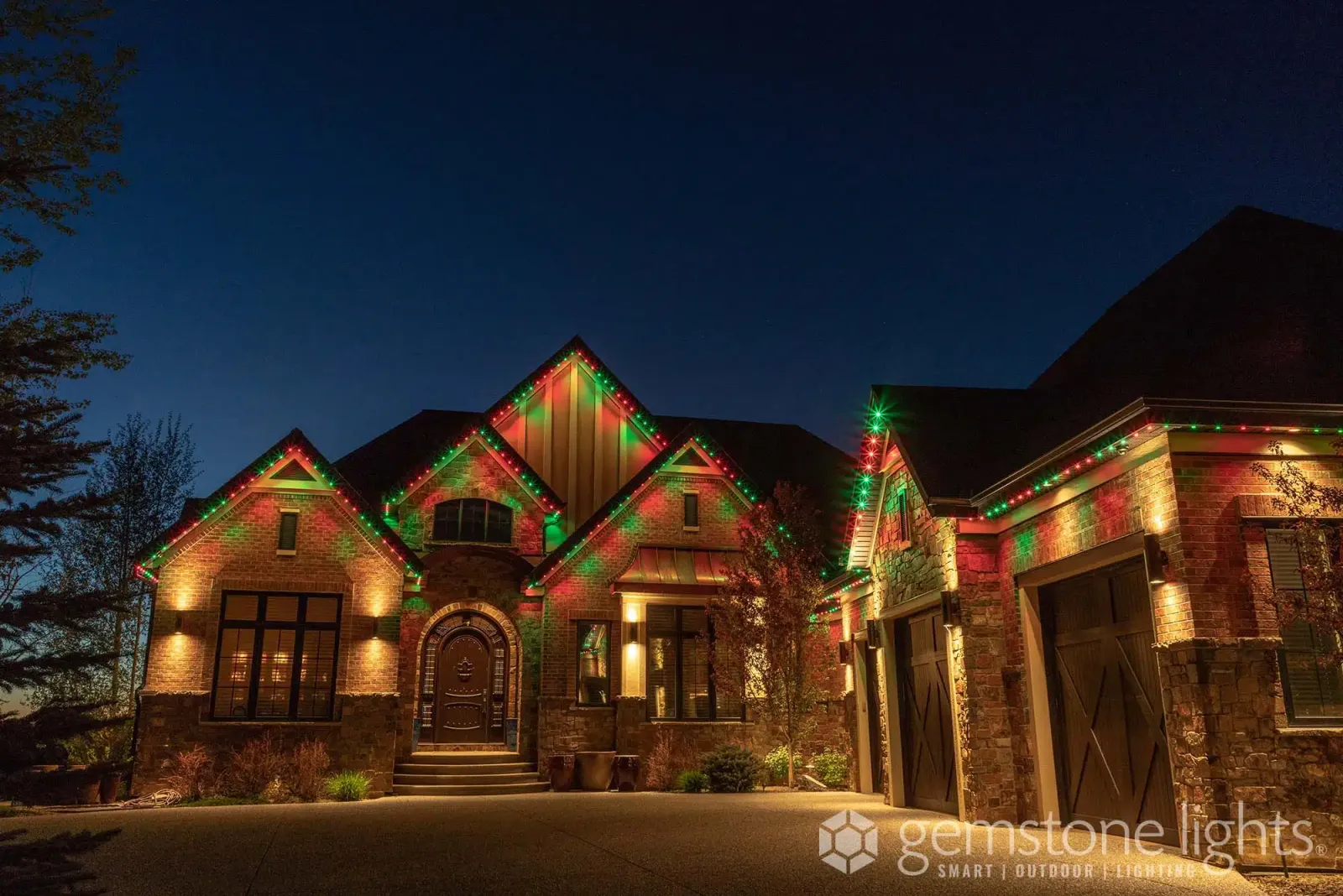 Brick home in red and green Christmas lights